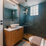 Luxury bathroom with walk-in shower and washing machine for guest use. Charys Premium Home.