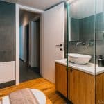 Luxury bathroom with walk-in shower and washing machine for guest use. Charys Premium Home.