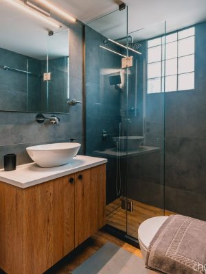 Luxury bathroom with walk-in shower and washing machine for guest use. Charys Premium Home.