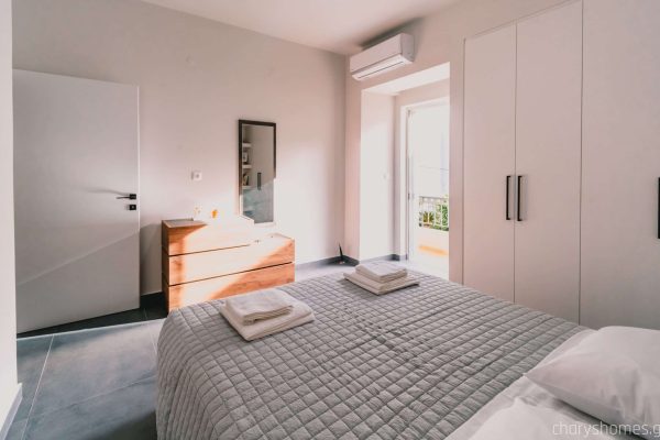 Luxury master bedroom featuring a wide queen-size bed with premium linens and a peaceful ambiance. Charys Premium Home